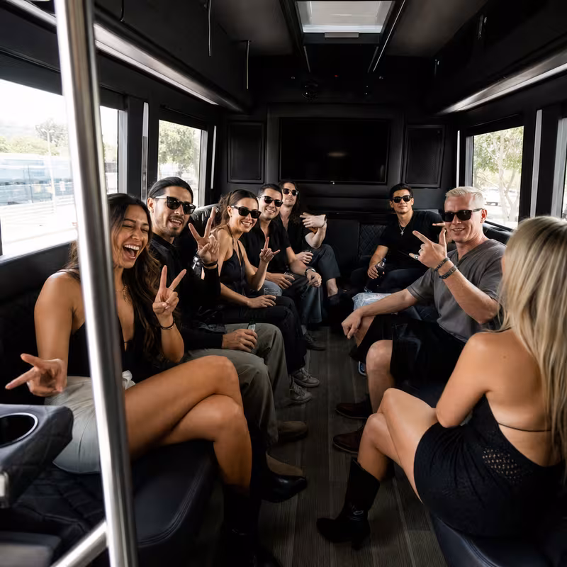 Group boarding a white charter bus for Concert Transportation transportation in Huntington Beach